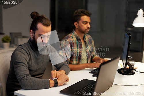 Image of creative man with smartwatch working at office