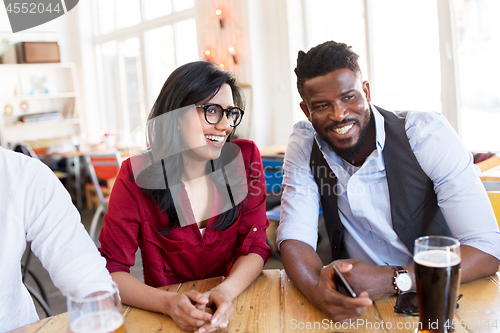 Image of happy man and woman with smartphone at bar