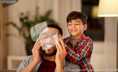 Image of happy father and little son playing at home