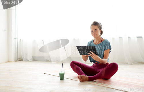 Image of woman with tablet pc and drink at yoga studio