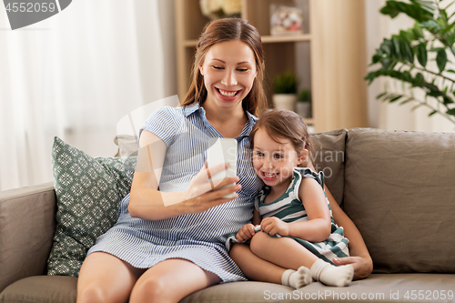 Image of pregnant mother and daughter with smartphone