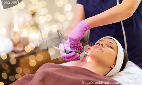 Image of young woman having face microdermabrasion at spa