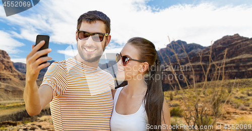 Image of couple taking selfie by smartphone on grand canyon