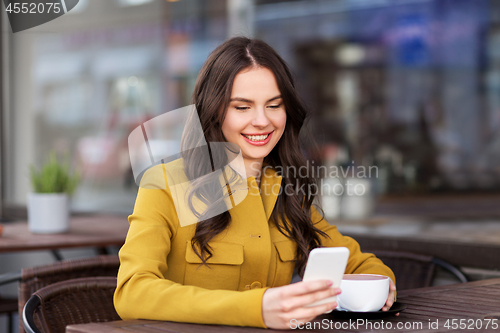 Image of teenage girl with smartphone and hot drink at cafe