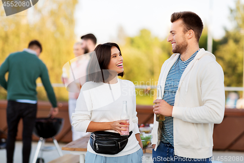 Image of happy couple with drinks at rooftop party