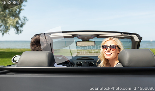 Image of happy man and woman driving in cabriolet car