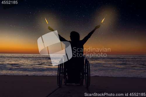 Image of Handicapped woman holding fire sparklers