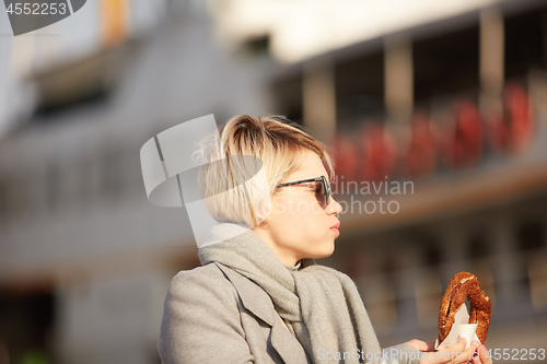 Image of Young woman eating turkish bagel in Istanbul, Turkey. Traditional turkish street food.