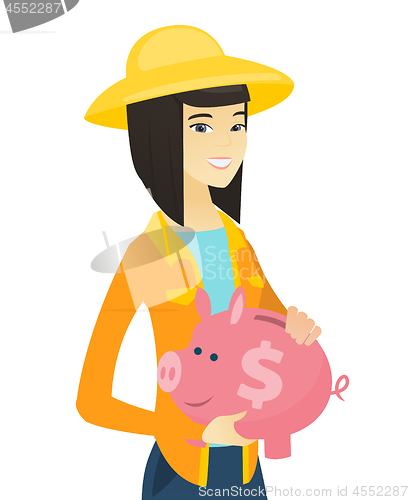 Image of Young asian farmer holding a piggy bank.