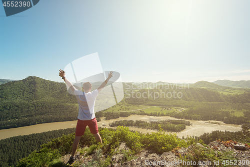 Image of Man standing on top of cliff