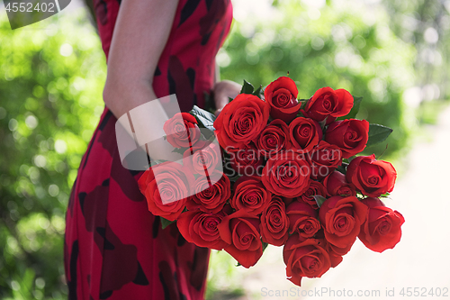 Image of Female hands holding beauty bouquet of red roses