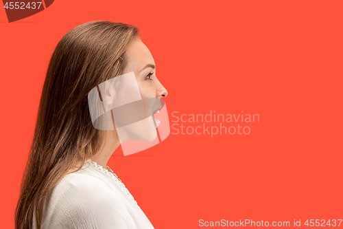 Image of Beautiful woman looking suprised isolated on red