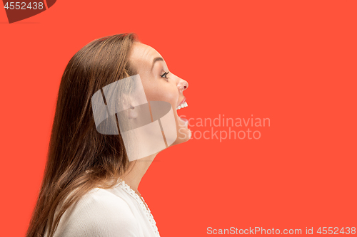 Image of The happy business woman standing and smiling against red background.