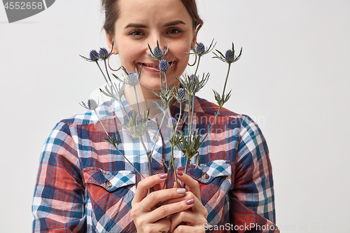 Image of Pretty girl with flowers eryngium