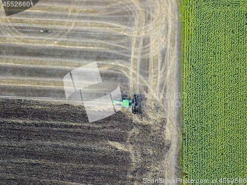 Image of Aerial view on the tractor working on the large sunflowers field sunny day