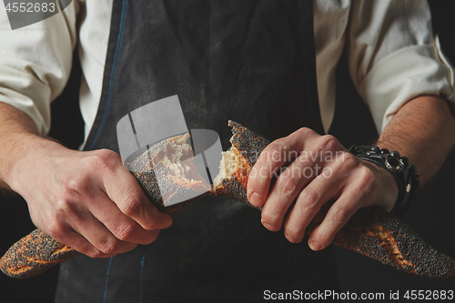 Image of hands men break the baguette