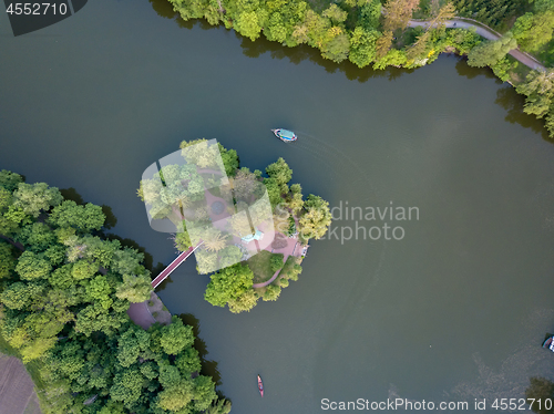 Image of small lake in the middle of a forest and an island with a bridge, top view