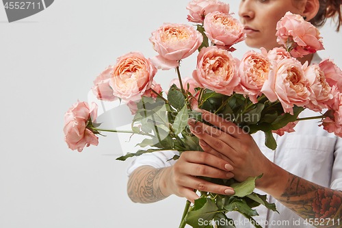 Image of bouquet of fresh pink roses, holding a girl