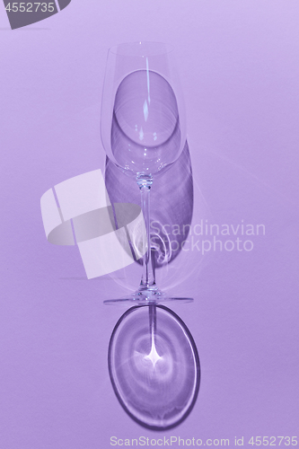 Image of Empty wine glass on a violet background