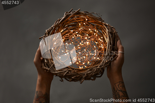 Image of Christmas wreath made of branches decorated with a Christmas lights