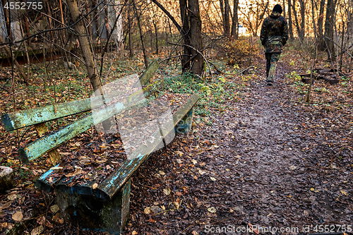 Image of Old destroyed bench next to path