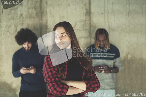 Image of casual multiethnic business team using mobile phones in front of