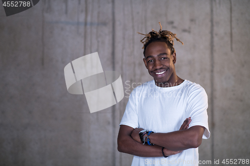 Image of portrait of black businessman in front of a concrete wall