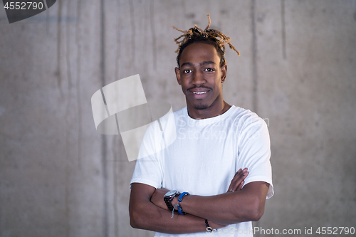 Image of portrait of black businessman in front of a concrete wall