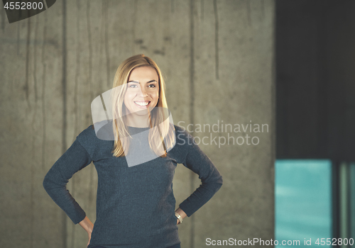 Image of portrait of casual businesswoman in front of a concrete wall