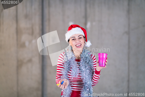 Image of young business woman wearing a red hat and blowing party whistle