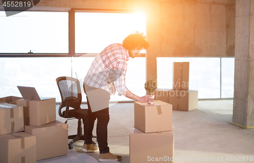 Image of business man holding plant in flowerpot