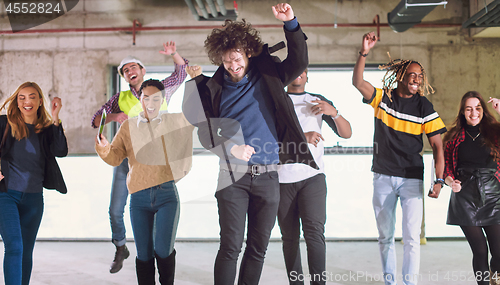 Image of young multiethnic business people dancing in unfinished startup 