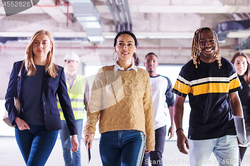 Image of young multiethnic business people walking through unfinished sta