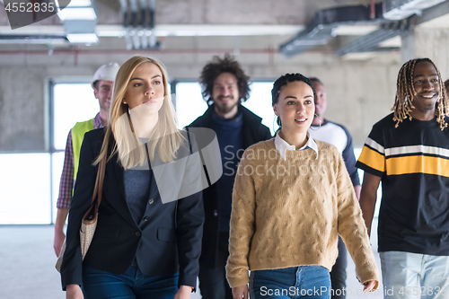 Image of young multiethnic business people walking through unfinished sta