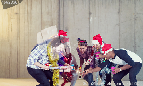 Image of multiethnic group of casual business people lighting a sparkler