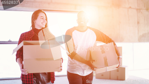 Image of multiethnic business team carrying cardboard boxes