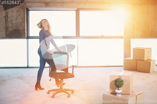 Image of business woman pushing office chair