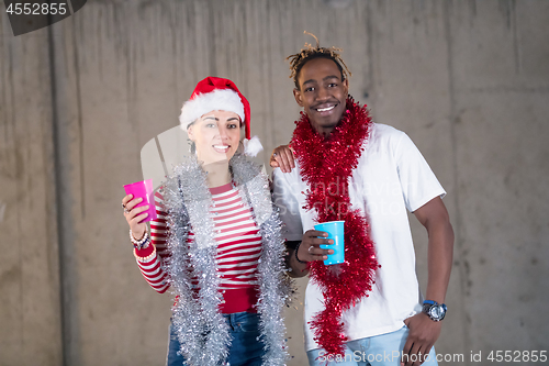 Image of young multiethnic business couple celebrating new year party