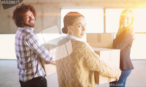 Image of business team carrying cardboard boxes