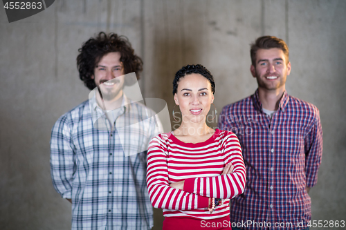 Image of portrait of casual business team in front of a concrete wall