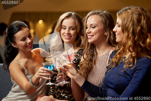 Image of happy women clinking glasses at night club