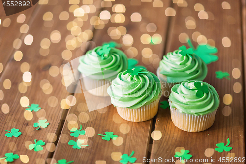 Image of green cupcakes and shamrock on wooden table