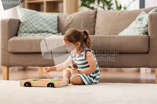 Image of happy baby girl playing with toy blocks at home