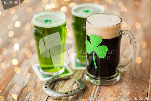 Image of shamrock on glass of beer and horseshoe on table