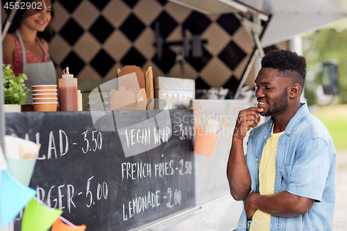 Image of male customer looking at billboard at food truck