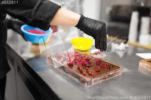 Image of confectioner makes chocolate dessert at sweet-shop