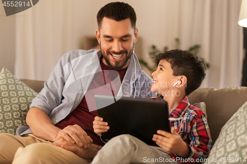 Image of father and son listening to music on tablet pc