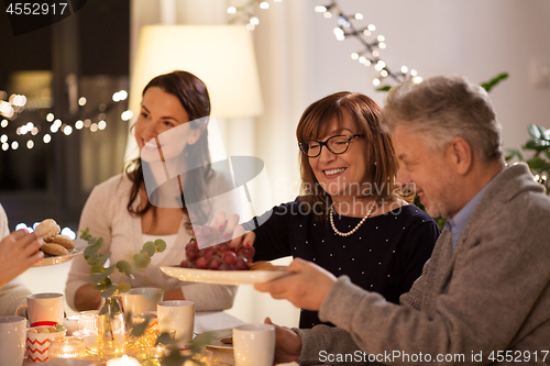 Image of happy family having tea party at home