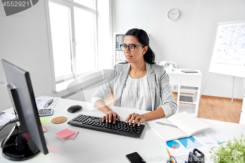 Image of businesswoman with computer working at office