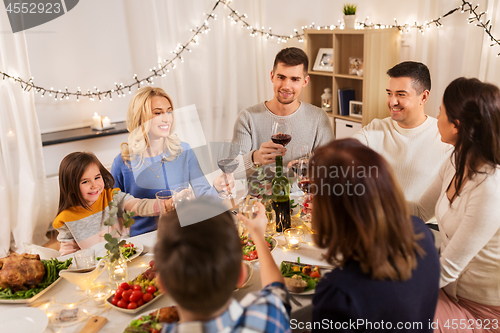 Image of happy family having dinner party at home